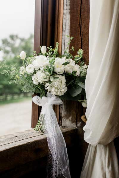 Classic white bridal bouquet with greenery by Garden by the Gate Floral Design. Venue Rivercrest Farm